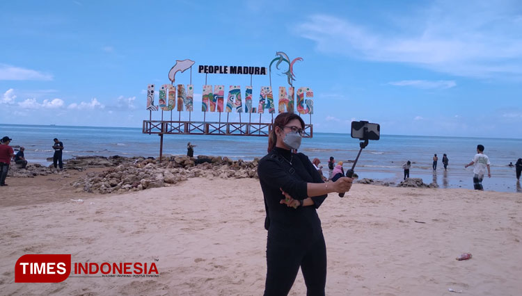 Pengunjung saat berfoto di Pantai Lon Malang, Sampang Madura. (Foto: Khusnul Hasana/TIMES Indonesia)