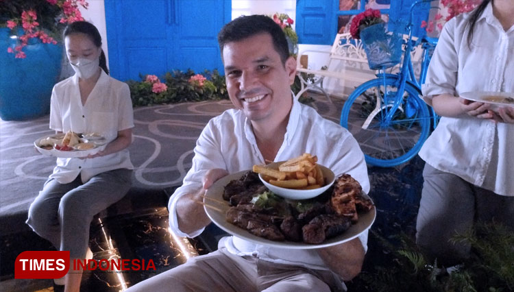 Pemilik Nostimo Greek Grill Bali, Alexios Filippidis (tengah) saat menghidangkan menu Yunani. (FOTO: Khusnul Hasana/TIMES Indonesia)