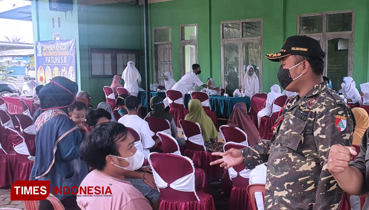 Kasat Korcab Banser Banyuwangi, Mahbub Junaidi saat berkomunikasi dengan peserta vaksinasi (Foto: Rizki Alfian/TIMES Indonesia)