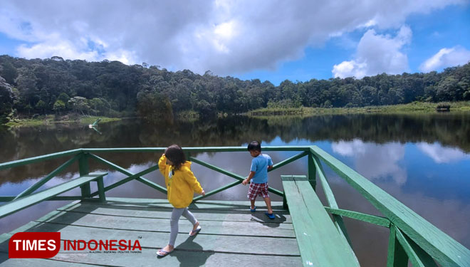 Dua bocah sedang bermain di tepi Danau Tambing. (Foto : Sarifah Latowa/TIMES Indonesia)  