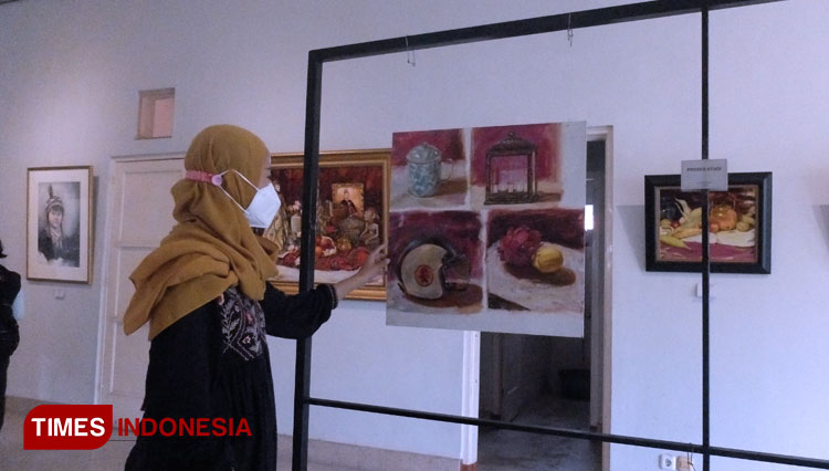 Ufa Fauziah saat menunjukkan karya lukisnya pada pameran tunggalnya The Beginning. (Foto: Khusnul Hasana/TIMES Indonesia). 