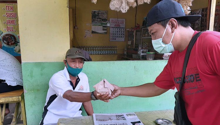 Relawan Komunitas Berbagi, membagikan nasi bungkus sekaligus mensosialisasikan kepada masyarakat untuk tetap disiplin menerapkan Prokes, Rabu (17/11/2021). (FOTO: Komunitas Berbagi for TIMES Indonesia)