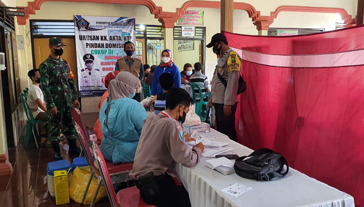 Babinsa Koramil Tipe B 0808/06 Srengat Kodim 0808/Blitar, Sertu Purnomo mendampingi warga mengikuti vaksinasi Covid-19 di Balai Desa Pakisrejo Kecamatan Srengat Kabupaten Blitar, Kamis (18/11/2021). (Foto: Kodim 0808/Blitar)