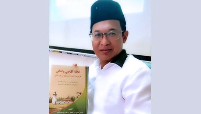 KH Zulfa Mustofa penulis Kitab Tuhfat al-Qashi wa al-Dani saat menunjukan karyanya (FOTO : Istimewa/NU Online)