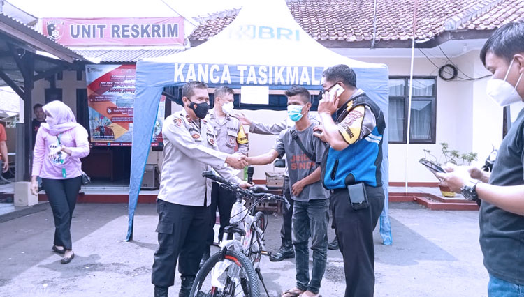 Seorang warga Kecamatan Tawang Kota Tasikmalaya menerima satu unit sepeda dari Kapolsek Tawang pada pelaksanaan Gerak Vaksinasi Presisi di Polsek Tawang Kota Tasikmalaya, Rabu (24/11/2021) siang. (FOTO: Humas Polres Tasikmalaya Kota/TIMES Indonesia)