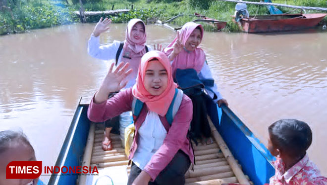 Siti Asiyatun (35) guru honorer di SDN Pandak 2 Kecamatan Klabang Kabupaten Bondowoso saat menyeberang sungai demi bisa sampai ke sekolah (FOTO: Moh Bahri/TIMES Indonesia).