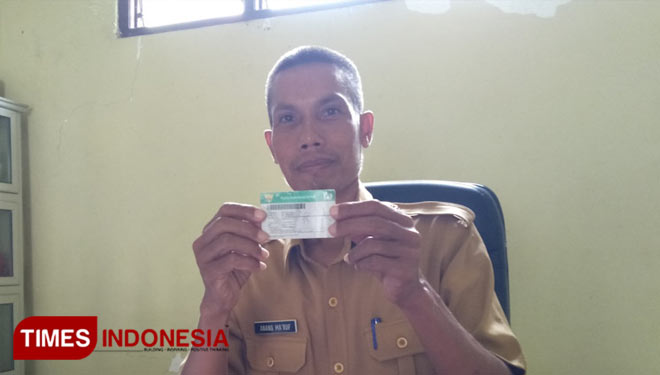 Kades Anang Ma'ruf saat membawa kartu JKN-KIS miliknya (Foto: Akmal/TIMES Indonesia).