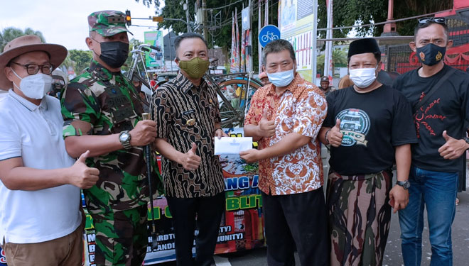 Wabup Blitar (Kiri) dan Dandim 0808/Blitar menyerahkan bantuan hasil lelang sepeda antik ke pihak Klenteng Poo An Kiong Kota Blitar, Jumat (3/12/2021). (Foto: Sholeh/TIMES Indonesia)