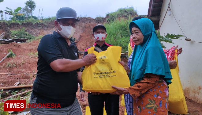 Anggota DPRD Majalengka Fraksi Golkar, M Suparman menyerahkan bantuan kepada korban bencana longsor. (Foto: Jaja Sumarja/TIMES Indonesia)