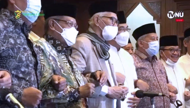 Para pengurus Syuriah dan Tanfidziyah PBNU bergandengan tangan usai penetapan Muktamar ke-34 NU sesuai hasil konbes. (foto: TVNU)