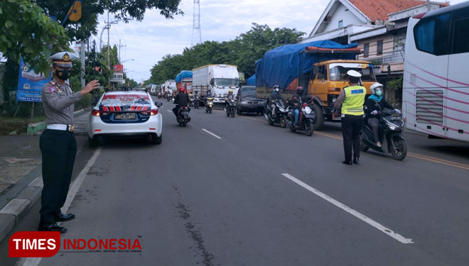 Kasatlantas Polres Lamongan, AKP Aristianto Budi Sutrisno, bersama anggotanya mengatur arus lalulintas di jalan poros Lamongan-Gresik yang mengalami kemacetan panjang, Senin (13/12/2021). (FOTO: MFA Rohmatillah/TIMES Indonesia)