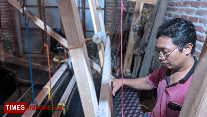 Budi Iswanto (37) pengrajin tenun dari Kabupaten Mojokerto saat menenun di rumah produksi rumah tangga miliknya di Dusun/Desa Kedung Guneng, Kecamatan Bangsal, Kabupaten Mojokerto, Rabu (22/12/2021) (Foto: Theo/TIMES Indonesia)