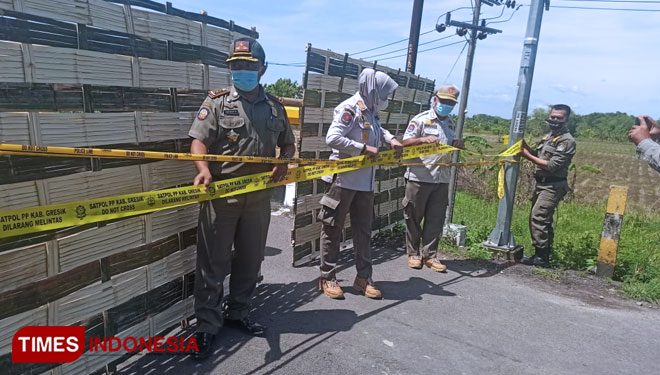 Satpol PP Gresik saat memasang Pol PP Line di Jembatan Kacangan Benjeng (Foto: Akmal/TIMES Indonesia)