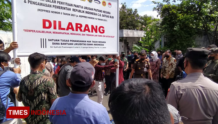 Satgas BLBI saat memasang papan penyitaan aset di depan pabrik PT Wastra Indah yang mangkrak bertahun-tahun. (Muhammad Dhani Rahman/TIMES Indonesia)