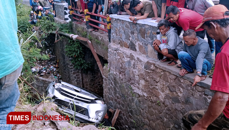 Evakuasi mobil jenis sedan yang masuk parit oleh pihak kepolisian Polsek Ciawi. Mobil diangkat dengan menggunakan mobil derek. (Foto: Anton/TIMES Indonesia)