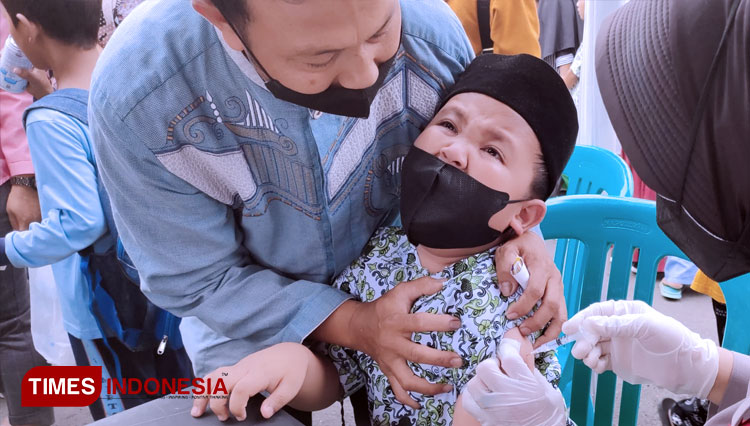 Seorang anak menerima vaksin dari seorang tenaga kesehatan, beberapa hari yang lalu di Graha Asri saat pelaksanaan tahun Laincing Vaksinasi anak Usia 6-11 tahun (FOTO: Harniwan Obech/TIMES Indonesia)
