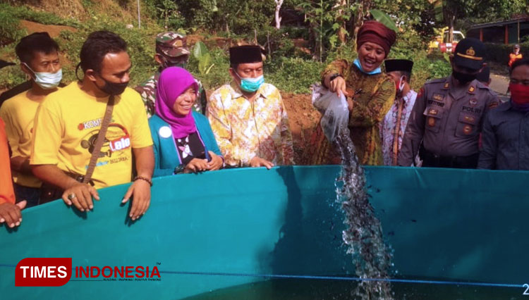 Luluk Nur Hamidah Saat menabur bibit lele di kolam (FOTO: Mukhtarul Hafidh/ TIMES Indoensia)