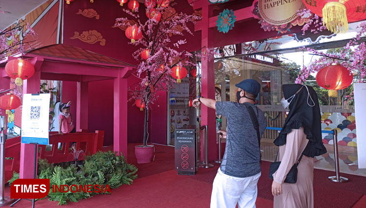 Terlihat pengunjung sedang berswafoto didepan lobby Lippo Plaza Jember yang dihiasi dengan ornamen Chinese New Year. (Foto: Siti Nur Faizah/TIMES Indonesia) 