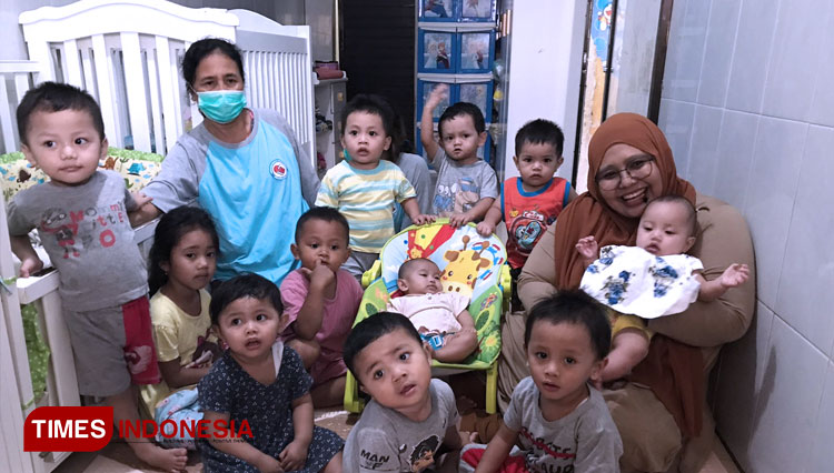 Nur Miftahul Jannah saat berfoto bersama anak-anak yang ia tampung di yayasan Peduli Kasih KNDJH, Senin (31/1/2022). (Foto: Rizky Kurniawan Pratama/TIMES Indonesia)