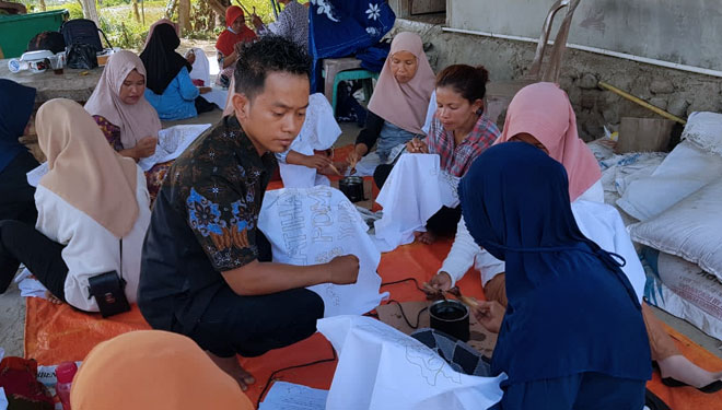 Andrianto di tengah-tengah ibu-ibu di Desa Pombewe Kecamatan Sigi Biromaru Kabupaten Sigi Sulawesi Tengah saat mengajari ibu-ibu membatik (FOTO: Andrianto for TIMES Indonesia)