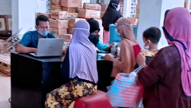 Pegawai distributor minyak goreng di Ngawi sedang menginput data pembeli. (Foto: Endrik for TIMES INDONESIA)
